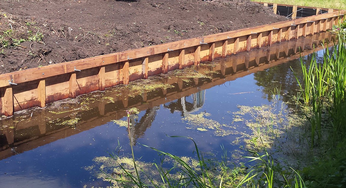 Hardhouten beschoeiing langs een waterkant